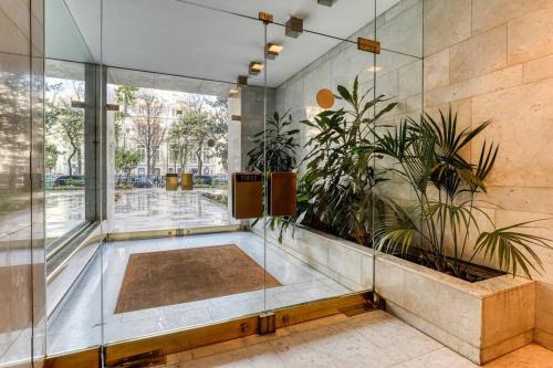 um átrio com plantas e uma parede de vidro em Montaigne Executive Suite em Paris