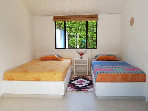 Un Paraíso para disfrutar y compartir cerca de Bogotá في ميلغار: غرفة نوم بسريرين ونافذة