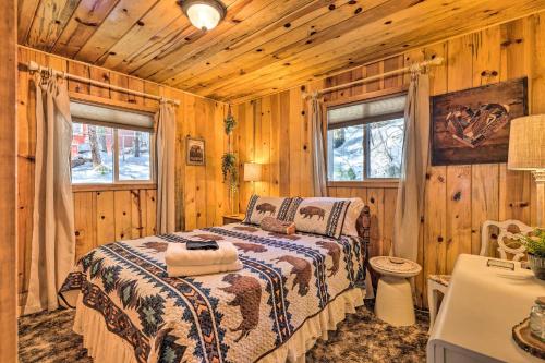 ein Schlafzimmer mit einem Bett in einer Holzhütte in der Unterkunft California Retreat with Deck, Fire Pit and Grill! in Long Barn