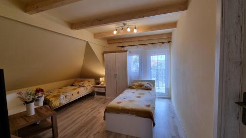 1 Schlafzimmer mit 2 Betten und einem Fenster in der Unterkunft Apartmány Sebastián in Pribylina