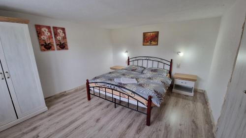 a bedroom with a bed with a wooden floor at Apartmány Sebastián in Pribylina