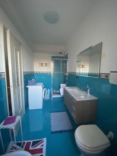 a blue bathroom with a toilet and a sink at La casa di Marta in Valeggio sul Mincio