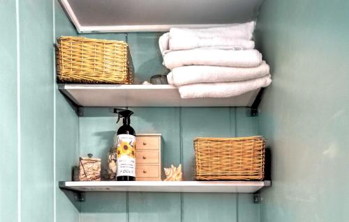 a towel rack with towels and baskets in a bathroom at Cape Cod Vacation Rental Walk to Beach! in Dennis Port