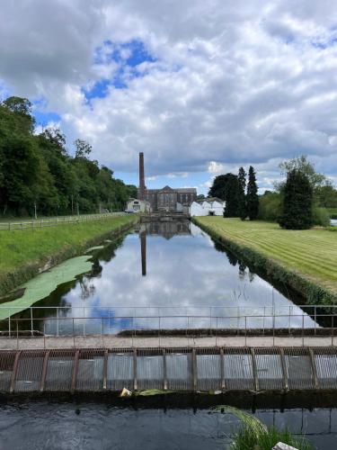 a canal with a mill in the background at Forest Hills Lodge in Slane