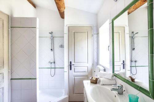 La salle de bains est pourvue d'une baignoire, d'un lavabo et d'un miroir. dans l'établissement Gîte St Roch en Luberon, à Castellet