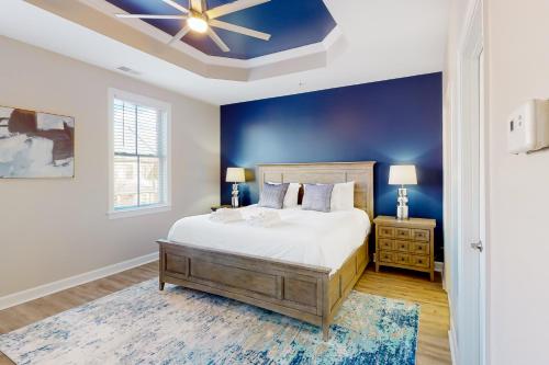 een slaapkamer met een bed en een blauwe muur bij Sunset Island - 57 Island Edge in Ocean City
