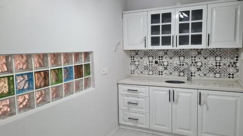 una cocina con armarios blancos y platos en la pared en Peri Suit Tunceli, en Tunceli