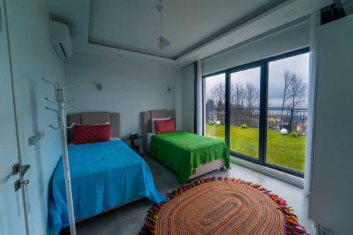 - une chambre avec 2 lits et une grande fenêtre dans l'établissement Sapanca villa, à Sapanca