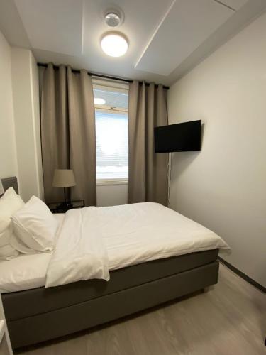 een slaapkamer met een wit bed en een raam bij Akselin & Elinan Asema Oy in Pyhäntä