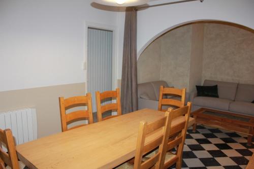 Un comedor con una mesa y sillas y un sofá. en Les Goelands, en Stella-Plage