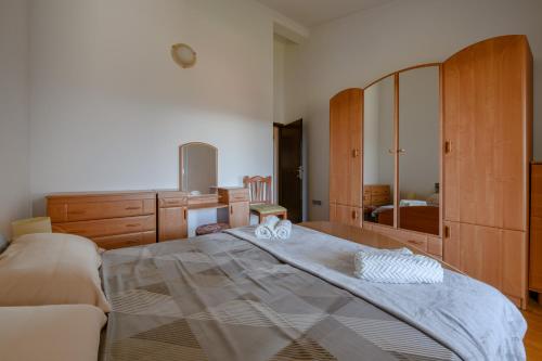 a bedroom with a large bed and a mirror at Apartman Noli in Rakalj