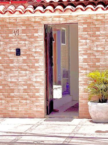 a brick building with a window and a potted plant at Pousada Praia do Recreio in Rio de Janeiro