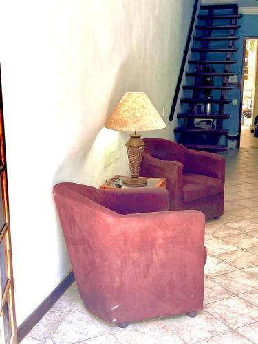a living room with two couches and a lamp on a table at Pousada Praia do Recreio in Rio de Janeiro