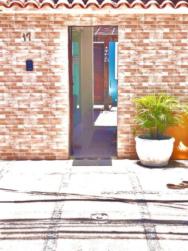an open door of a brick building with a plant at Pousada Praia do Recreio in Rio de Janeiro