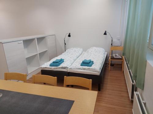 Habitación pequeña con cama y sillas. en Apartment Junki, en Alavieska