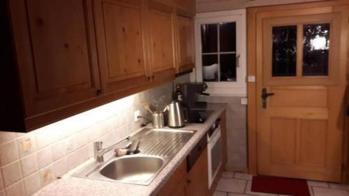 uma cozinha com um lavatório, uma janela e uma porta em Ferienwohnung Südhang Rüschegg em Rüschegg