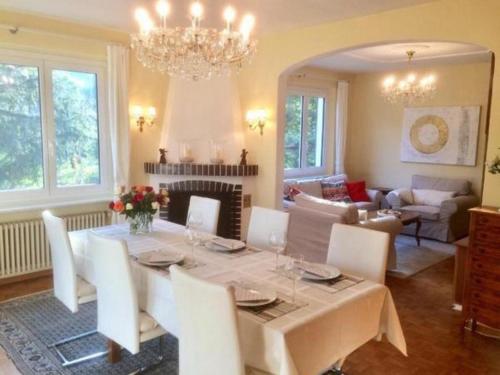 une salle à manger avec une table et des chaises blanches dans l'établissement "CASA ELENA -Tegna" die Ruheoase in grossem mediterranem Garten, à Tegna