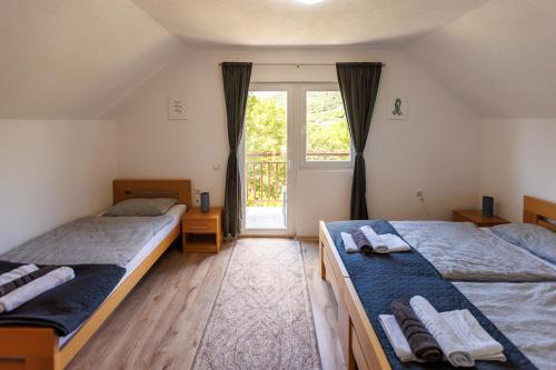 two beds in a room with a window at Aparthouse Bilic in Jajce