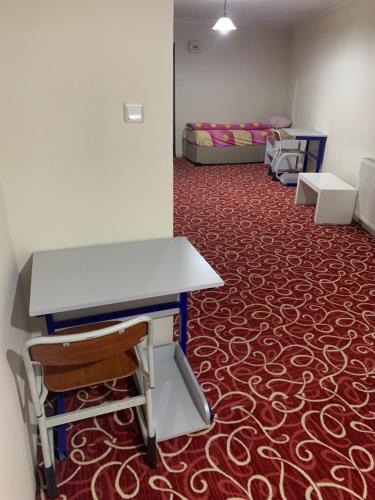 a room with a desk and a bed and a carpet at Amkara apart hostel 5 in Altındağ