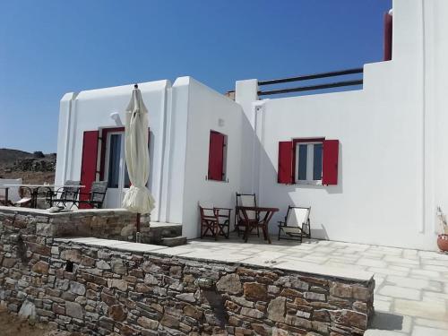- une terrasse avec des chaises et un parasol dans un bâtiment dans l'établissement Kythnos - Loutra- House, à Loutrá