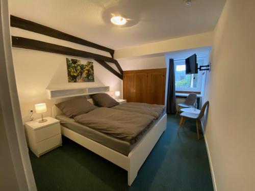 a bedroom with a bed and a desk and a chair at Weinzeit Kröv in Kröv