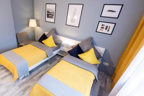 um pequeno quarto com duas camas com amarelo e azul em Bremerhavener Suite 5 em Bremerhaven