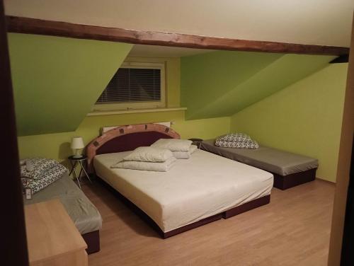 a bedroom with two beds and a green wall at Penzion U bílého jaka in Vilémov