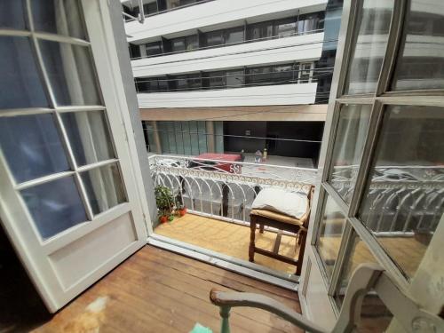 a balcony with a chair and a window at Casa de Huéspedes Cristina Recoleta Cristina Guesthouse Recoleta in Buenos Aires