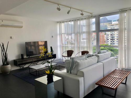 リオデジャネイロにあるIpanema com Todo Confortoのリビングルーム(白いソファ、テレビ付)
