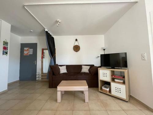 a living room with a couch and a coffee table at Appartement tout confort 2-4 pers 500 m de la plage avec piscine et wifi in Santa-Maria-Poggio