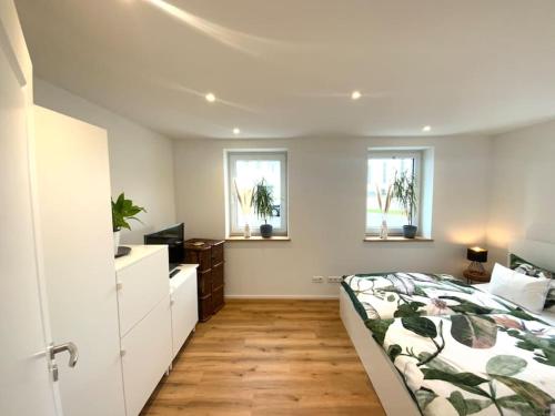 1 dormitorio con 1 cama y 2 ventanas en Ferienwohnung Weitblick, en Ravensburg