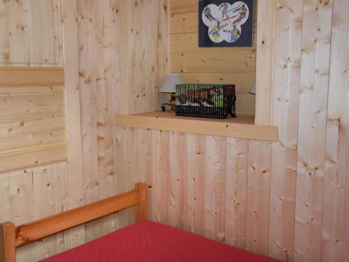 Cette chambre est dotée d'un mur en bois avec une étagère. dans l'établissement Appartement 3 pièces en rez-de-jardin, animaux admis - FR-1-464-183, à Pralognan-la-Vanoise