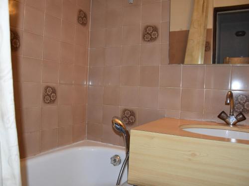 une salle de bain avec une baignoire et un lavabo dans l'établissement Studio Charmant Proche Centre, Balcon Sud, Calme, Capacité 4 Pers., Près Commerces et Téléphérique - FR-1-464-173, à Pralognan-la-Vanoise