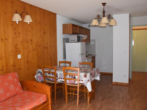 une cuisine et une salle à manger avec une table et des chaises dans l'établissement Appartement cosy avec piscine, proche centre et téléphérique - 4 pers. - FR-1-464-165, à Pralognan-la-Vanoise