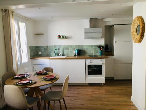 a kitchen with a table and chairs in a kitchen at Chez Louise et Lucette in Sanary-sur-Mer