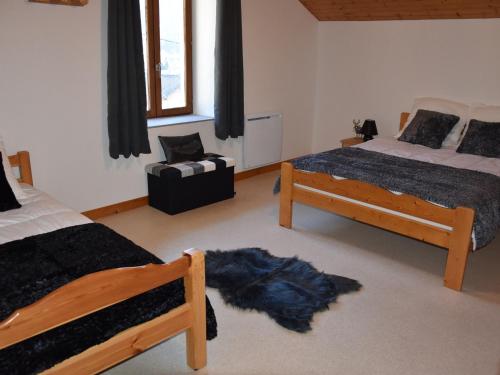 une chambre avec deux lits et une chaise dans l'établissement Duplex lumineux avec mezzanine, proche pistes et centre, balcon sud, garage inclus - FR-1-464-194, à Pralognan-la-Vanoise