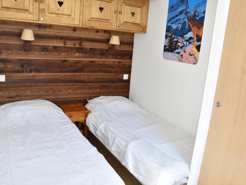 two beds in a room with wooden walls at Appartement Confort 4 Pers., Balcon, Piscine, Près Centre & Téléphérique - FR-1-464-200 in Pralognan-la-Vanoise