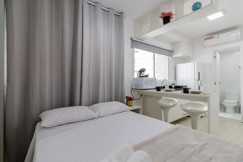 a white bedroom with a bed and a bathroom at Studios Modernos Totalmente Mobiliados com Academia Próximo a Metrô Parque Ibirapuera e Hospitais in Sao Paulo