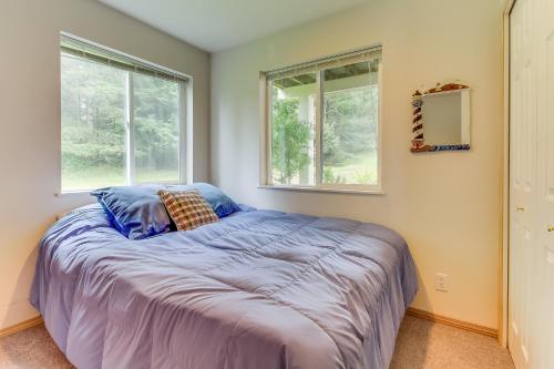 a bedroom with a large bed with two windows at Shoal Bay Luxury Home in Port Stanley