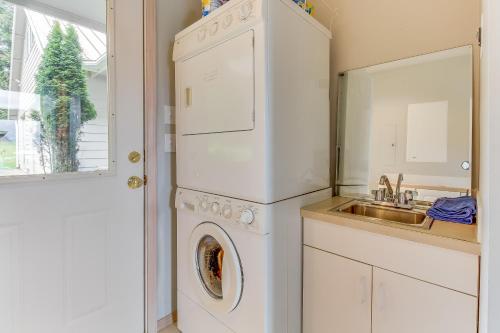 a kitchen with a washer and dryer next to a sink at Shoal Bay Luxury Home in Port Stanley