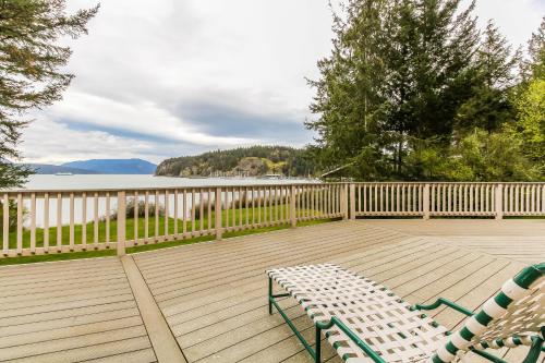 a deck with two chairs and a bench on it at Shoal Bay Luxury Home in Port Stanley