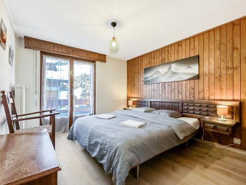 een slaapkamer met een groot bed en een houten muur bij Instant sports & ski Paradise in Verbier