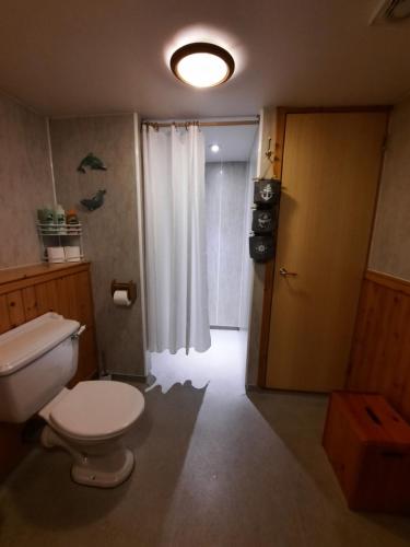 a bathroom with a toilet and a window and a door at One bedroom self-contained accommodation in Lerwick