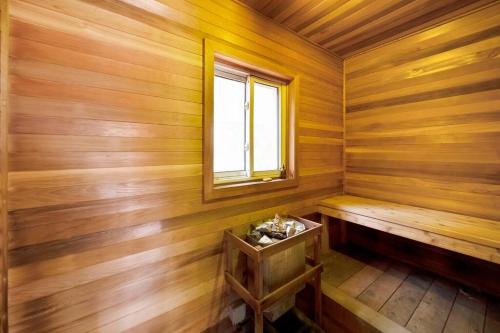 a sauna with a bench and a window at Modern Chic Cottage - Hot Tub, Sauna, Tay Trail in Waubaushene