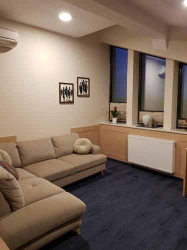 a living room with a couch and two windows at Centrum Misji Afrykańskich - centrum hotelowo-konferencyjne in Borzęcin Duży
