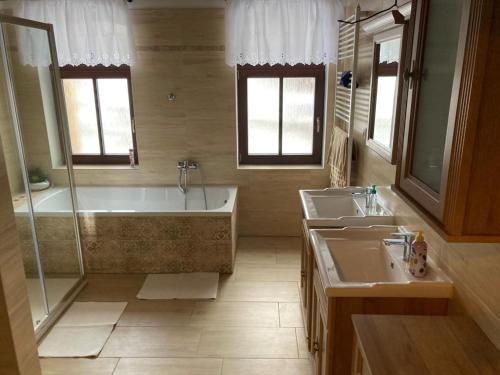 a bathroom with two sinks and a tub and a shower at Chalupa Madla in Kalek