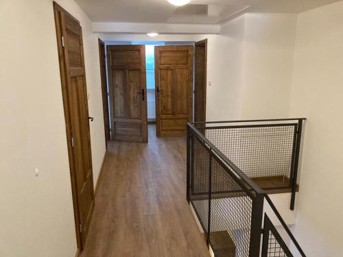 a hallway with a staircase and two wooden doors at Chalupa Madla in Kalek