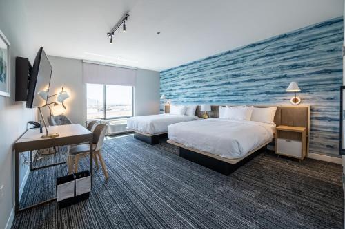 a hotel room with two beds and a wall mural at TownePlace Suites by Marriott Norfolk in Norfolk