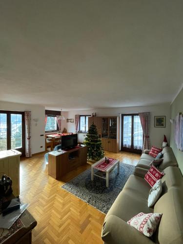 a living room with a couch and a christmas tree at Appartamento Panorama Bormio in Bormio