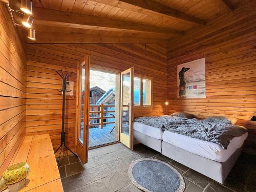 a bedroom with a bed in a wooden cabin at Le Dernier Mot in Bruson